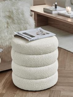 a stack of white pillows sitting on top of a wooden floor