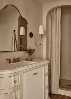 a bathroom with a sink, mirror and shower