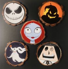 four painted wooden slices with jack and sally faces on them, all in different colors