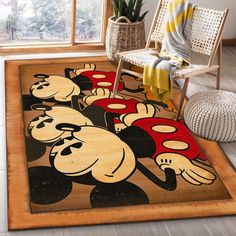 a mickey mouse rug is on the floor next to a chair and potted plant