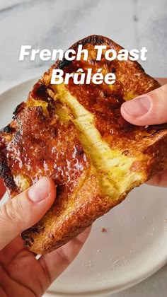 a person holding a piece of bread with cheese on it and the words french toast brulee