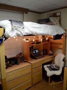 a bunk bed with a desk underneath it and lights strung from the ceiling above it