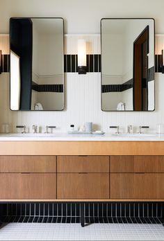 a bathroom with two sinks and three mirrors