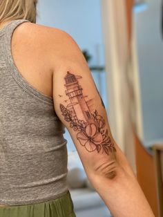 a woman with a lighthouse tattoo on her arm