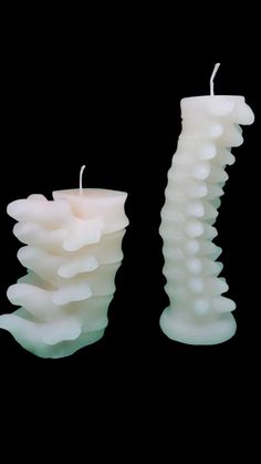 two white candles sitting next to each other