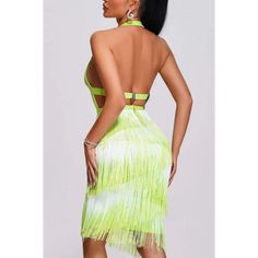 a woman wearing a neon green dress with fringes on the skirt and backless top