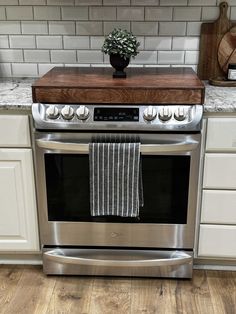 a kitchen with white cabinets and stainless steel appliances, including an electric stove top oven