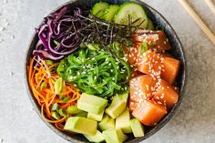 a bowl filled with different types of food and chopsticks on top of it