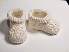 Looking for the perfect addition to your baby's wardrobe? Look no further than our collection of handmade crochet baby booties and crib shoes! Each pair of booties is carefully crafted by hand using high-quality yarn and designed with comfort and style in mind. Our baby booties come in a variety of colors and styles, from classic neutrals to fun and vibrant patterns. They are perfect for keeping little feet warm and snug, and the soft and stretchy material ensures a comfortable fit. Our crochet White Knitted Booties For Winter, White Knitted Winter Booties, White Booties As Winter Gift, White Winter Booties As A Gift, White Winter Booties As Gift, Cute Knitted Booties As Gift, Cute Yarn Booties As A Gift, Cute Yarn Booties As Gift, Cute Knitted Round Toe Booties