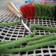 there is a pair of scissors on the table next to some green and red yarn