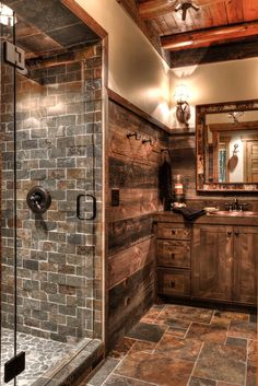 a rustic bathroom with stone walls and tile flooring, along with a walk in shower