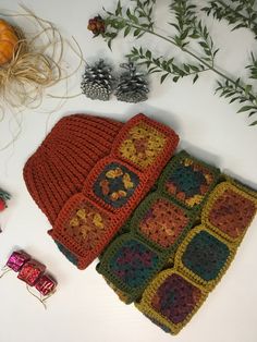 there are crocheted squares on the table next to pine cones and other items