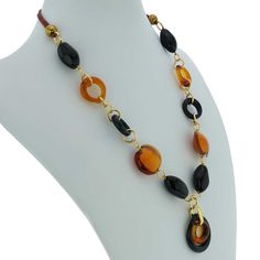 This gorgeous contemporary Murano Glass necklace in golden brown and black color palette features an exquisite design of concentric rings in the center suspended from a beaded necklace. This Italian necklace is an example of unique hand-made Murano Glass jewelry that demonstrates why Murano glass makers have been held in high regard around the world for ages. This versatile piece of Italian jewelry can be worn with your evening or casual outfits and will add Venetian elegance and Italian style t Elegant Brown Round Beaded Necklaces, Elegant Brown Round Beaded Necklace, Elegant Brown Round Necklaces, Elegant Brown Round Necklace, Elegant Long Brown Necklace, Elegant Murano Glass Beaded Necklaces, Gold Murano Glass Single Strand Necklace, Elegant Murano Glass Necklace With Polished Beads, Elegant Round Murano Glass Necklace