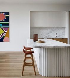 a modern kitchen with an island and bar stools