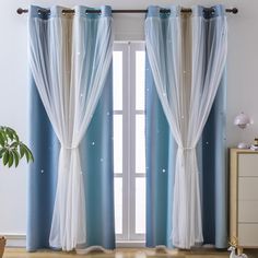 a living room with blue and white drapes on the windowsills, two planters in front of them