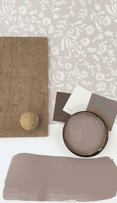 the wall paper is next to some paint samples and a plate with a gold button