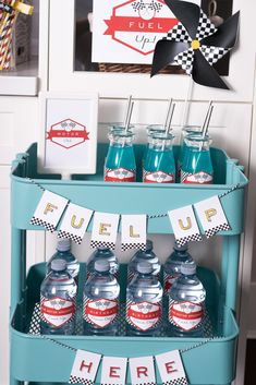 a blue cart filled with water bottles on top of a table