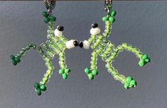 green and white beaded earrings hanging from hooks