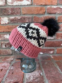 a knitted hat with a pom - pom sits on top of a head