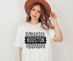 "Houston Shirt, Houston Souvenir Shirt, Texas T-shirt, Proud Texan Shirt, Houston Native Shirt,  Houston Sport Tee, Houston Leopard Shirt, Made to order T-shirt original design by Nicomedia Designs.  A part of the World Cites T-shirt line. Hey, y'all! Welcome to Nicomedia. I hope our small shop will make you happy. If you have any questions or want to buy a custom design, please contact us. We are always happy to help.  HOW TO ORDER A SHIRT 1-) Please check and review all photos. 2-) Select your Fan Apparel T-shirt With Custom Print And Short Sleeves, Relaxed Fit Fan Apparel T-shirt With Custom Print, Custom Print Short Sleeve T-shirt For Fans, Pre-shrunk Relaxed Fit Fan Apparel Shirt, Relaxed Fit Fan Apparel Shirt, Relaxed Fit Pre-shrunk Fan Apparel Shirt, White Custom Print Shirt For Fan Merchandise, Souvenir Shirt, Leopard Shirt