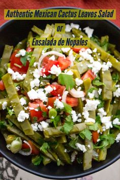 a bowl filled with green beans, tomatoes and feta cheese on top of it