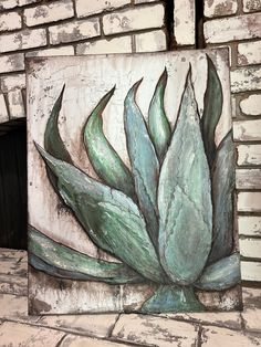 a brick wall with a painting of a green plant on it's side next to a fire place