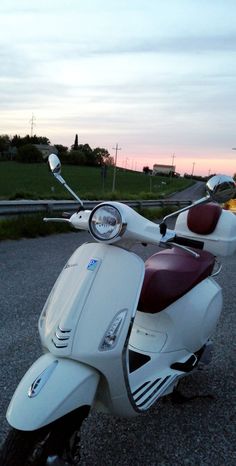 a scooter is parked on the side of the road at sunset or dawn