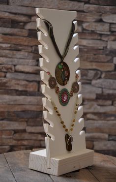 a wooden stand with several necklaces on it