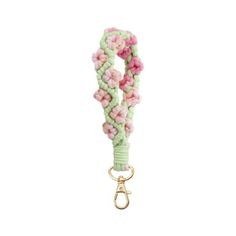 a green and pink lanyard with flowers on the end, hanging from a gold hook