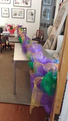 purple and green streamers sitting on top of a table in front of a couch