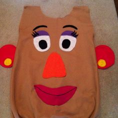 a child's costume made to look like a face with eyes and nose on the ground