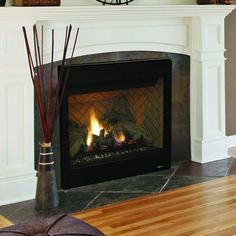 a fireplace with a clock on the mantle above it and candles in vases next to it