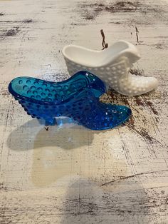 two blue and white glass bowls sitting on top of a wooden table next to each other