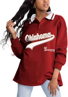 a woman wearing a red shirt with the word oklahoma on it and white trim around her neck