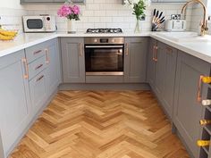 a kitchen with grey cabinets and wooden floors