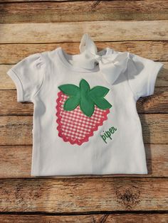 This custom strawberry shirt is a hit all year round! Perfect for strawberry festivals, summer staple and birthdays too!  I use high quality shirts for embroidery and they are 100% cotton that soft and run TTS.  This listing is for one puff sleeve shirt not a tank. If you would like a tank as shown please message me based on availability. (Tanks will not be ribbed)  Shirts are available in 12M-10Y. Onesies are available from sizes 0-3m to 18m. BOW IS NOT INCLUDED IN THIS LISTING.  Fabrics may slightly differ but will be from the same patterns and color scheme pictured.  Please let me know if you'd like any changes made when placing your order. If you'd like something different please message me! When ordering don't forget to include the full name and thread color you would like in the note Sweet Cotton Summer Shirt, Sweet Summer Cotton Shirt, Sweet Short Sleeve Cotton Shirt, Fitted Cotton T-shirt With Strawberry Print, Cute Strawberry Print Shirt, Summer Cotton Shirt For Birthday, Cotton Shirt For Birthday In Summer, Cute Strawberry Print Shirt For Spring, Pink Strawberry Print Shirt For Spring