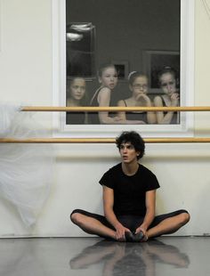 a woman sitting on the floor in front of a window