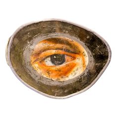 an eye in a frying pan on a white background with orange and brown streaks