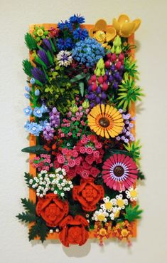 an arrangement of colorful flowers is displayed on the wall in this art work by artist and photographer