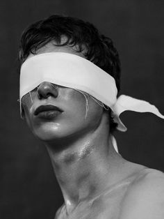 black and white photograph of man with blind folded over his face