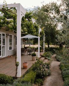 an outdoor patio with white pergola and potted plants