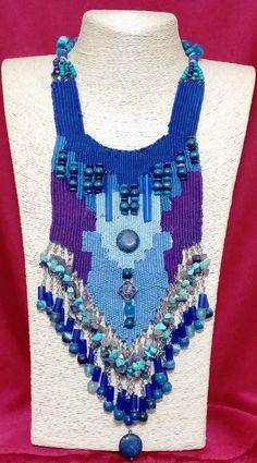 a blue and purple beaded necklace on a mannequin