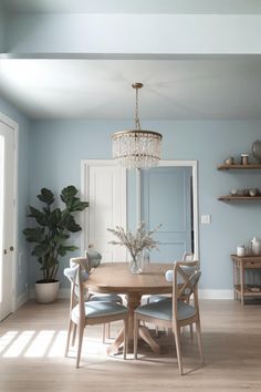 a dining room table with chairs and a chandelier hanging from it's ceiling