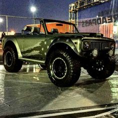 an army green truck parked on top of a parking lot