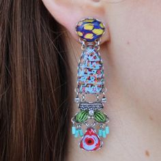 Feeling blue has never looked this good! The Carnival Dalia Earrings use multiple materials like European crystal, Czech glass beads, and other textiles. With hues of blue and red with accents of green and yellow, these earrings are sure to liven up your ensemble and your mood. The round post is linked on both sides to an elongated oval that has a lively print. Linked to that section are an assortment of baubles and charms varying in shapes and colors. You are sure to have a blast styling these Handmade Multicolor Bohemian Clip-on Earrings, Bohemian Multicolor Clip-on Earrings For Gift, Multicolor Bohemian Drop Clip-on Earrings, Bohemian Multicolor Clip-on Earrings As A Gift, Vibrant Blue Drop Earrings, Bohemian Multicolor Beaded Clip-on Earrings, Vibrant Blue Dangle Earrings, Handmade Blue Bohemian Clip-on Earrings, Multicolor Handmade Clip-on Earrings