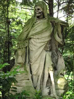 the statue is covered in green moss and has a skeleton on it's head