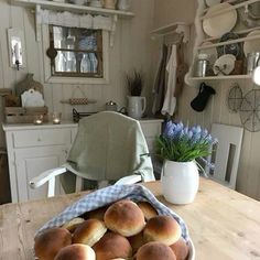 a bowl full of rolls sitting on top of a wooden table