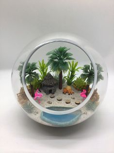 a glass bowl with some plants and animals in it