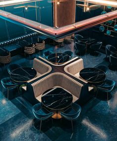 the interior of a restaurant with black and gold chairs, tables and mirrors on the wall