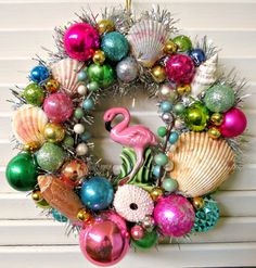 a christmas wreath decorated with ornaments and flamingos